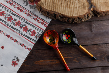 wooden Russian hand-painted spoons and tablecloth with a traditional pattern on natural wooden background.