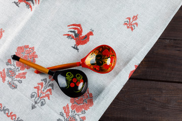 wooden Russian hand-painted spoons and tablecloth with a traditional pattern on natural wooden background.
