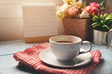 Cup of Coffee with Desktop Calendar 2019 and pot of rose flower on blue wooden desk,Working space at home,Urban Lifestyle concept