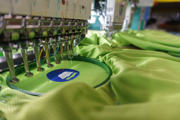 Embroidery machine needle in Textile Industry at Garment Manufacturers, Embroidery T-shirt in progress, Needle with thread (selective focus and soft focus)