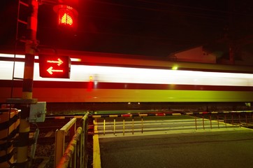 夜の踏切の通過電車