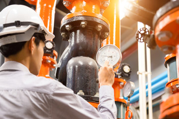Asian engineer maintenance checking technical data of  system equipment Condenser Water pump and...