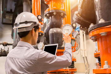 Asian engineer maintenance checking technical data of  system equipment Condenser Water pump and...