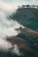 Fototapeta premium Casa rodeada de neblina y montañas 