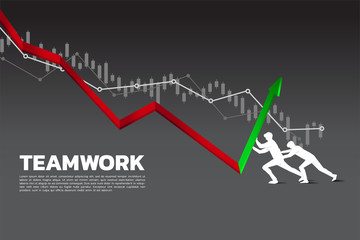 Obraz premium Silhouette of two businessman pushing the graph to up direction.stop financial crisis . concept of business challenge and teamwork.