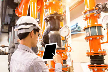 Asian engineer maintenance checking technical data of  system equipment Condenser Water pump and...