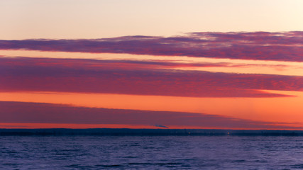 Sunset pink and red clouds over the lake