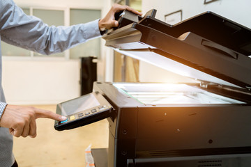 Business man Hand press button on panel of printer, printer scanner laser office copy machine supplies start