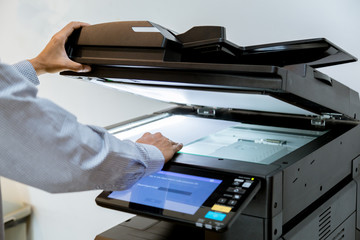 Business man Hand press button on panel of printer, printer scanner laser office copy machine supplies start
