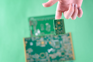 Small Electronics Circuit Boards on human woman finger.
