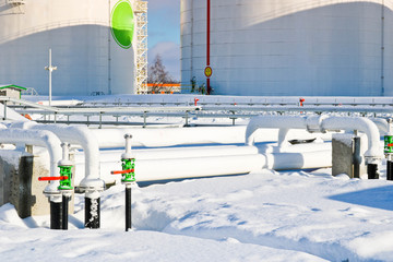 Large white iron metal industrial tanks for storage of fuel, gasoline and diesel and pipeline with...