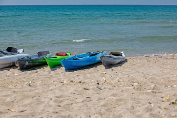 Colourful kayaks on sandy beach. The concept of active rest
