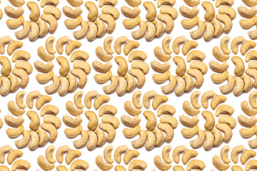 A collection of cashew nuts lie in the shape of a circle or sun on an isolated white background with a clipping path. Cashew Pattern