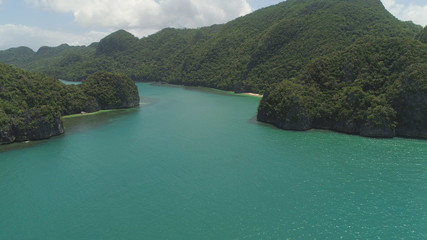 Obraz premium Aerial view coastline with beach and mountains covered with tropical forest in province Caramoan, Philippines. Landscape with sea, mountains and beach.