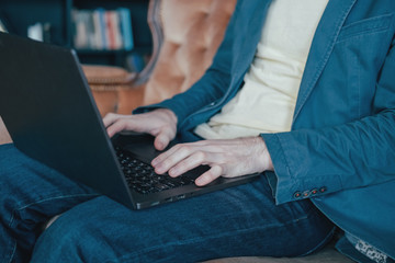 The man in casual working at laptop, close up