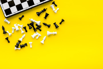 Symbol of competition. Chess board and chess figures on yellow background top view space for text