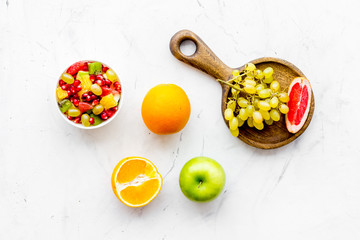 Healthy diet concept. Fruit salad near fresh fruits on white background top view