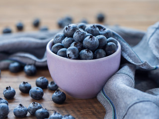 Bluelerry in ceramic bowl on wood floor.