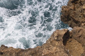 Close-up of natural rock formation with the wave at Timang Beach in sunny day, Yogyakarta, Indonesia