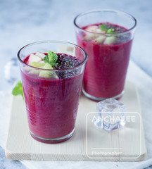 Glass of beetroot smoothie mix with apple, kiwi, chia seed and ice for detox and healthy drink on wood tray, black and white background.
