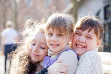 Fototapeta premium Three sisters sitting on bench in park.