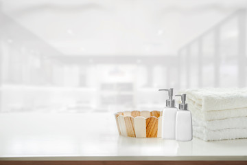 Mockup towels, empty wooden bucket and soap bottle on white table