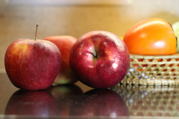 Two red ripe apples are on the table