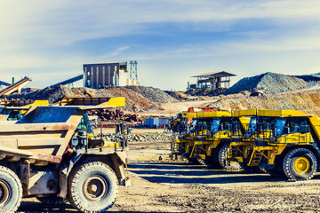 Old and new dumper trucks face to face in the Riotinto mine with old buildings in the background © Juanrastock