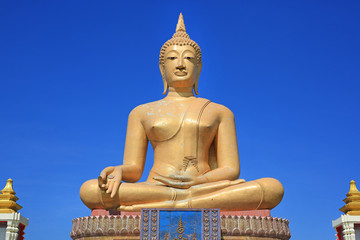 Fototapeta premium Beautiful of golden Big Buddha against blue sky background in Sing Buri, Thailand.
