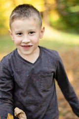 smiling young boy without front teeth in the park
