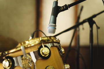 Two microphone and drums in studio for recording.