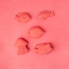 Color of year 2019 Living Coral concept. Fish toys set on living coral background, monochrome vacation summer minimal concept