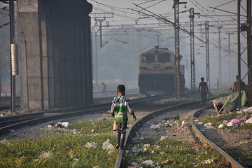 インドの首都のデリー　線路で遊ぶ少年　線路を走るインド鉄道