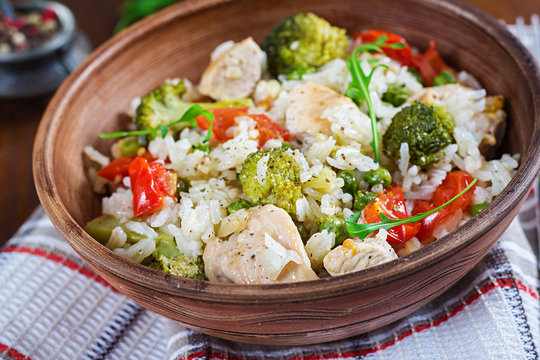 Delicious chicken, broccoli, green peas, tomato stir fry with rice. Asian cuisine. Healthy food.