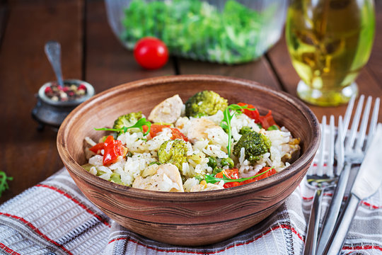 Delicious chicken, broccoli, green peas, tomato stir fry with rice. Asian cuisine. Healthy food.