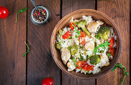 Delicious chicken, broccoli, green peas, tomato stir fry with rice. Asian cuisine. Healthy food. Top view