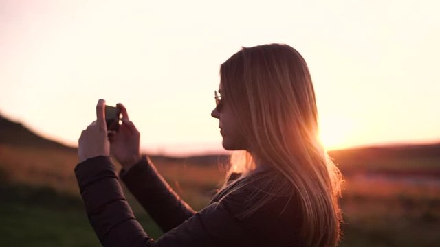 Tourist taking photograph of sunset in Iceland