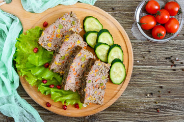 Liver casserole. Useful dish from the liver. Freshly baked pork liver souffle with rice and vegetables on a wooden table.