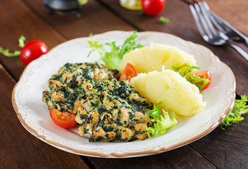 Baked steak chopped chicken fillet with spinach and a side dish of mashed potatoes. European cuisine. Dietary food.