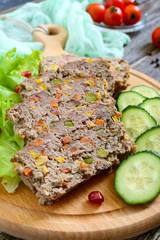 Liver casserole. Useful dish from the liver. Freshly baked pork liver souffle with rice and vegetables on a wooden table.