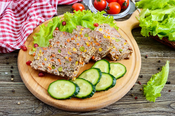 Liver casserole. Useful dish from the liver. Freshly baked pork liver souffle with rice and vegetables on a wooden table.