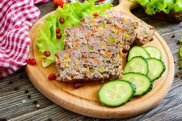 Liver casserole. Useful dish from the liver. Freshly baked pork liver souffle with rice and vegetables on a wooden table.