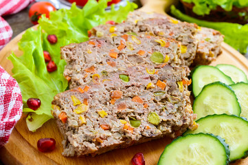 Liver casserole. Useful dish from the liver. Freshly baked pork liver souffle with rice and vegetables on a wooden table.