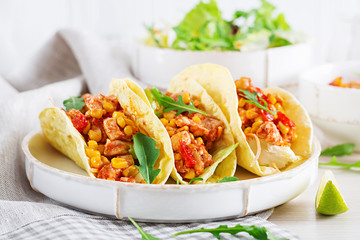Mexican tacos with chicken meat, corn and tomato sauce. Latin American cuisine. Taco, tortilla, wrap.