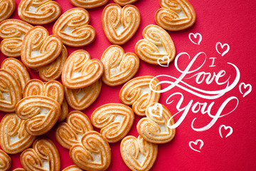 I Love You hand drawn calligraphy text. Cookies for Heart Day or Valentine Day in heart shape on red background.