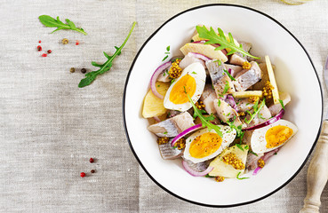 Traditional  salad of salted herring fillet, fresh apples,  red onion  and eggs. Kosher food. Scandinavian cuisine. Top view. Flat lay