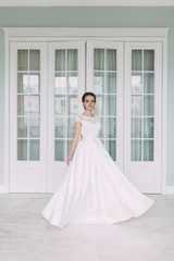 Obraz premium The bride in the white Studio with a bouquet. Wedding in the European style fine art.