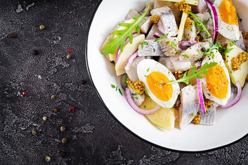 Traditional  salad of salted herring fillet, fresh apples,  red onion  and eggs. Kosher food. Scandinavian cuisine. Top view. Flat lay