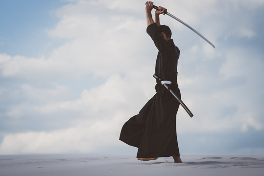 Man training martial arts in desert