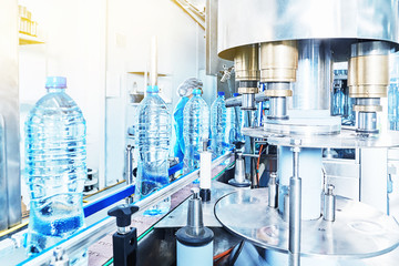 Female worker checking out water bottles.